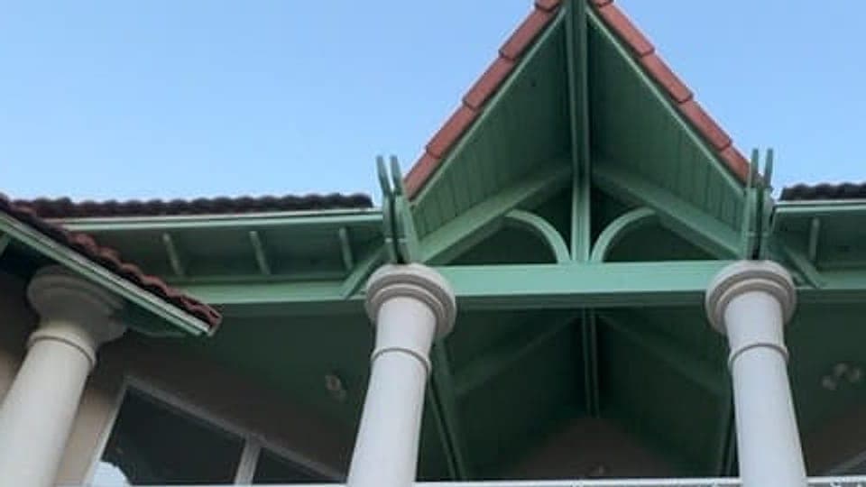 Green gable trim, clay tile roof and white columns on a coastal home